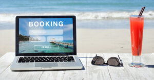Laptop with travel website with ocean front in background