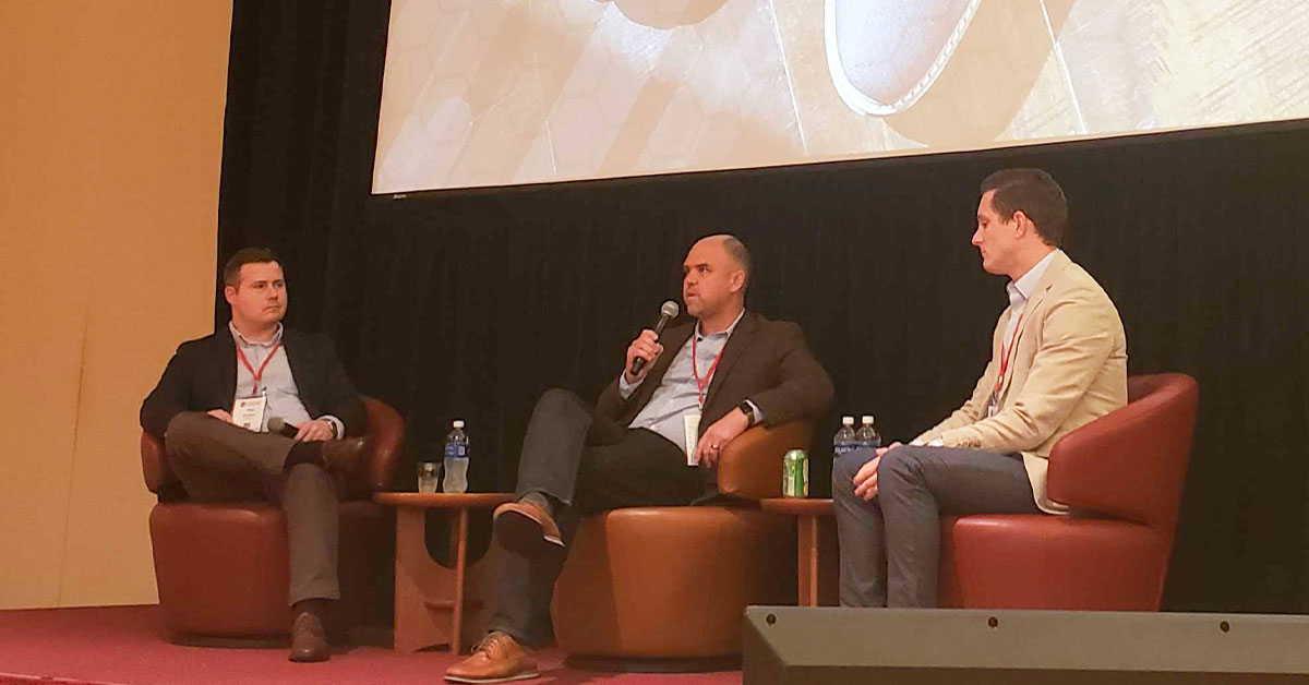 Three men sitting with microphones