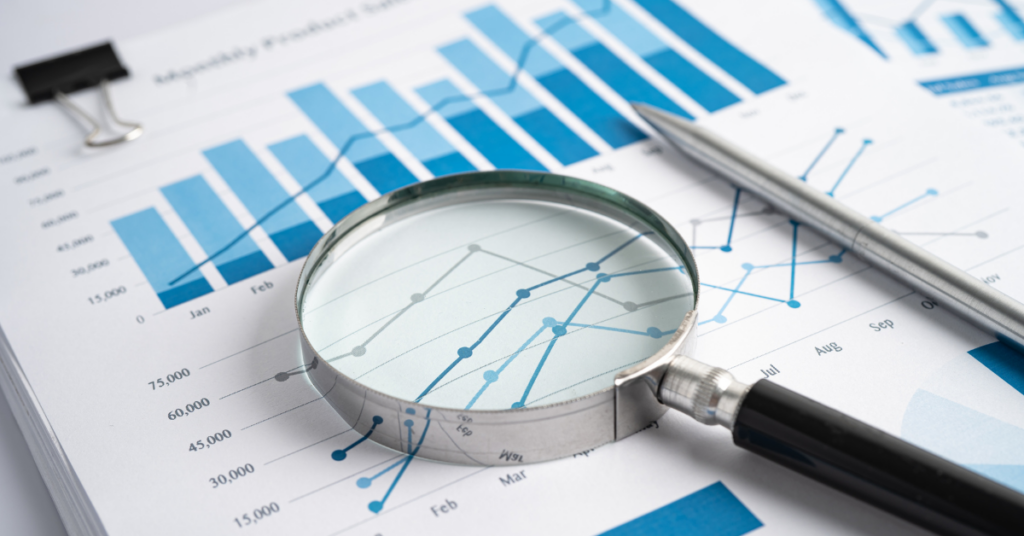 A magnifying glass over charts and graphs, suggesting the interpretation of a/b test results.