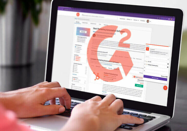 Person at laptop displaying G2 logo and website