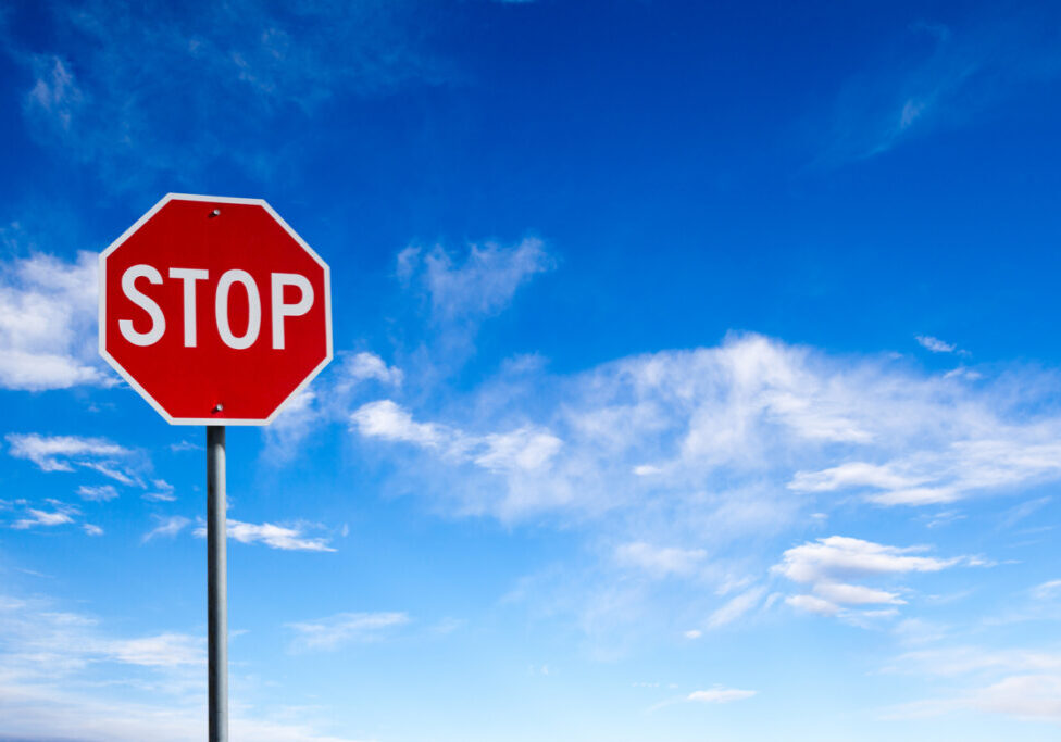 Conceptual stop sign with blue sky background and copy space.